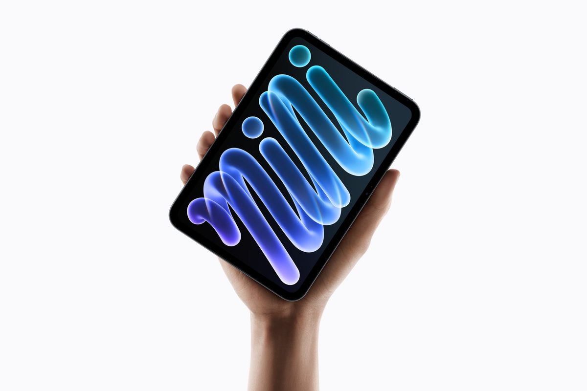 A hand holding the new iPad mini with its OLED display showing a blue 'mini' wallpaper animation