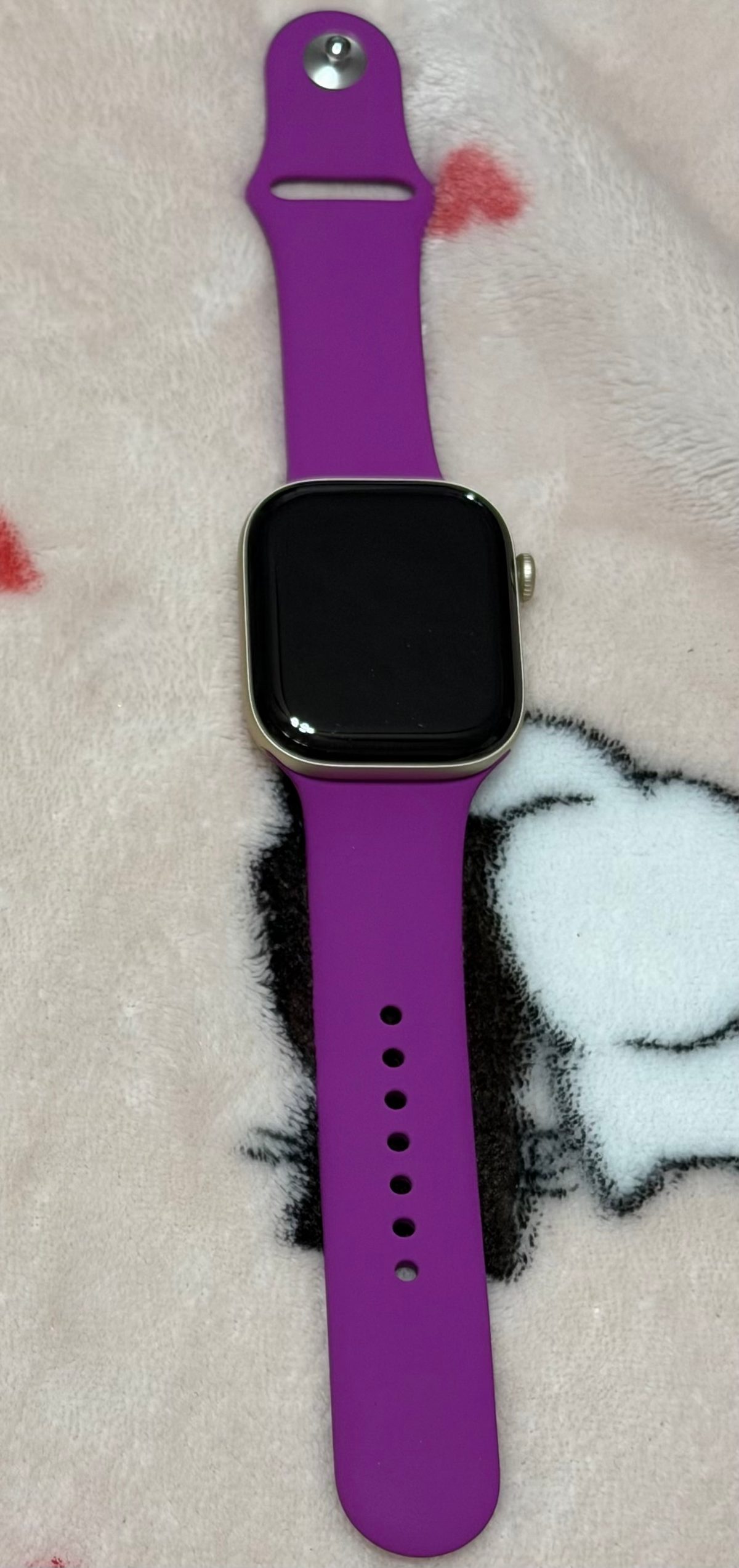 A Light Gold aluminum Apple Watch Series 12 with a magenta Sport Band