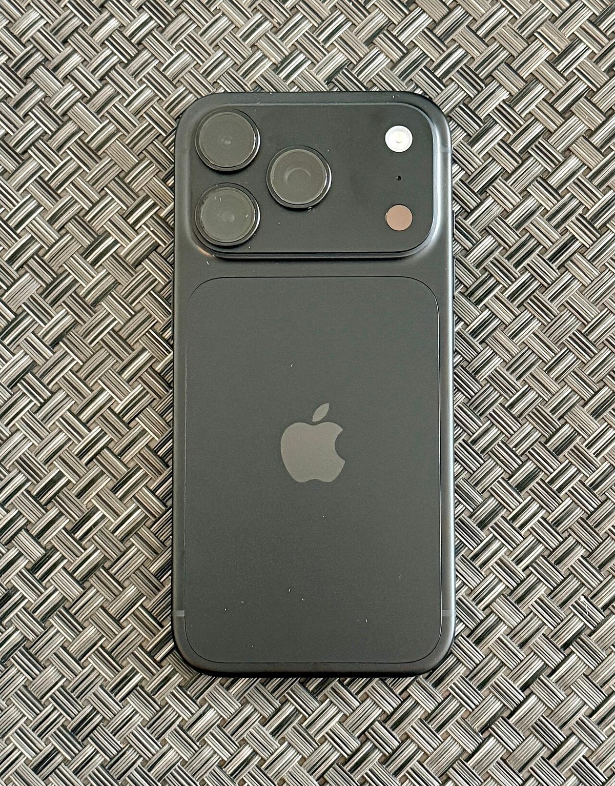 iPhone 18 Pro in black, rear view showing the triple-camera module and Apple logo