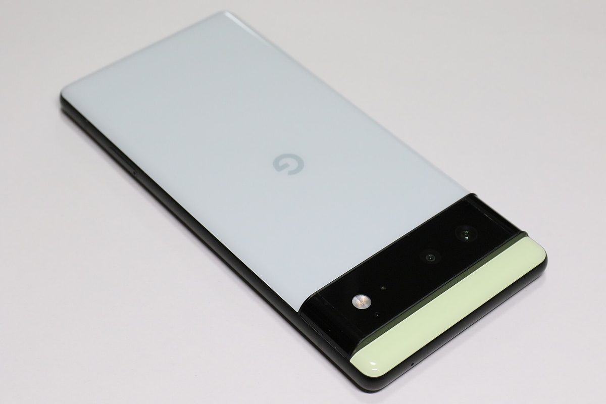 Google Pixel 6 in Sorta Seafoam lying on a white surface, rear view with the black camera bar