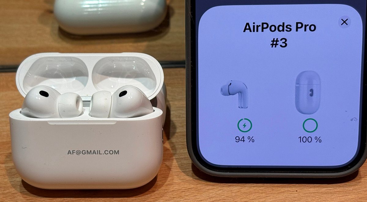 Apple AirPods Pro 3 earbuds in their charging case, paired to an iPhone showing 94% and 100% battery